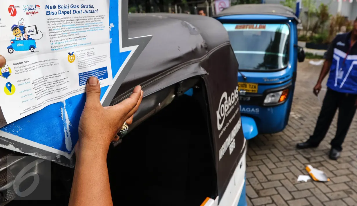 Supir bajaj sedang menempel stiker naik bajaj gas gratis di MRU PGN Station IRTI Monas, Jakarta, Minggu (14/08). Kegiatan ini merupakan bagian dari program BUMN Hadir Untuk Negeri. (Liputan6.com/Fery Pradolo).
