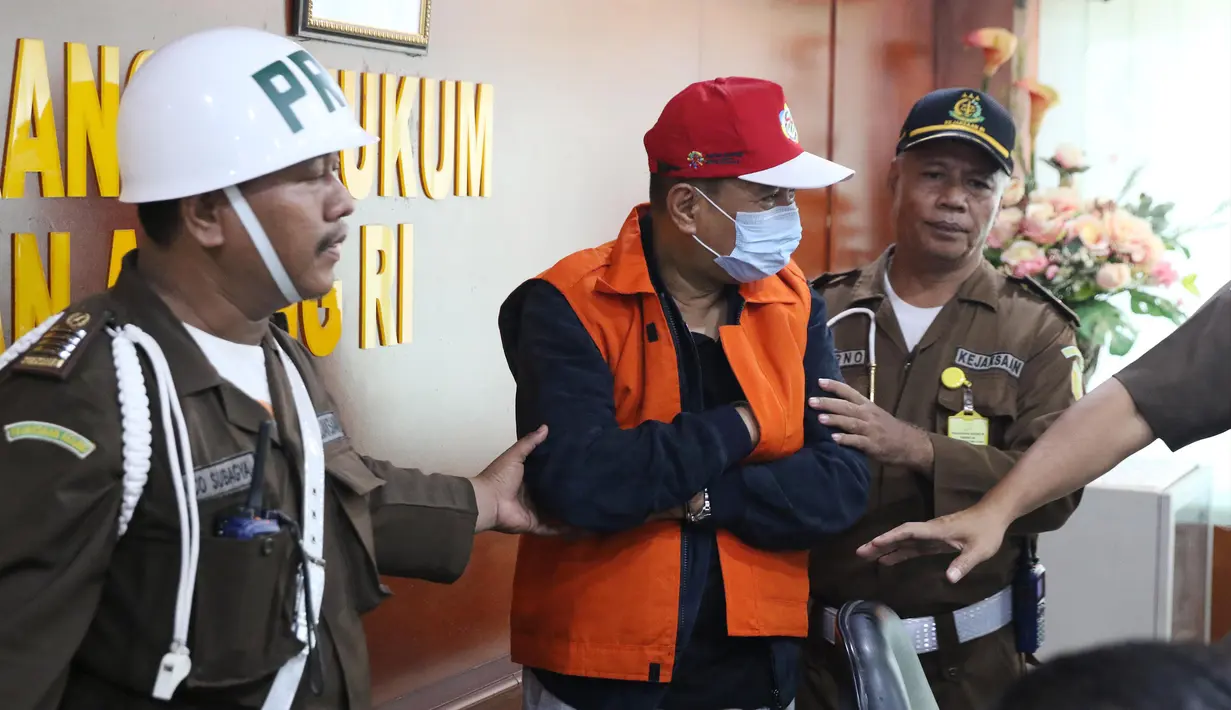 Buronan koruptor Atto Sakmiwata Sampetoding (tengah) digiring petugas di Gedung Kejaksaan Agung, Jakarta, Kamis (21/11/2019). Tim Kejagung bersama Ditjen Imigrasi dan KBRI Kuala Lumpur memulangkan buronan koruptor Rp 24 miliar yang telah divonis 5 tahun penjara. (Liputan6.com/Helmi Fithriansyah)