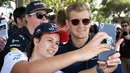 Pembalap Tim Sauber asal Swedia, Marcus Ericsson melakukan selfie dengan seorang penggemar menjelang sesi latihan bebas pertama di Grand Prix Australia, Melbourne, Jumat (24/3). (AFP Photo/WILLIAM WEST)