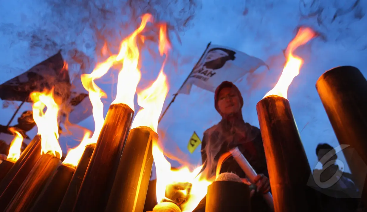 Puluhan buruh wanita menyalakan obor saat menggelar aksi memperingati 22 tahun tanpa keadilan "Malam Marah Marsinah" di Kawasan Berikat Nusantara (KBN) Jakarta, Jumat (8/5/2015). (Liputan6.com/Faizal Fanani)