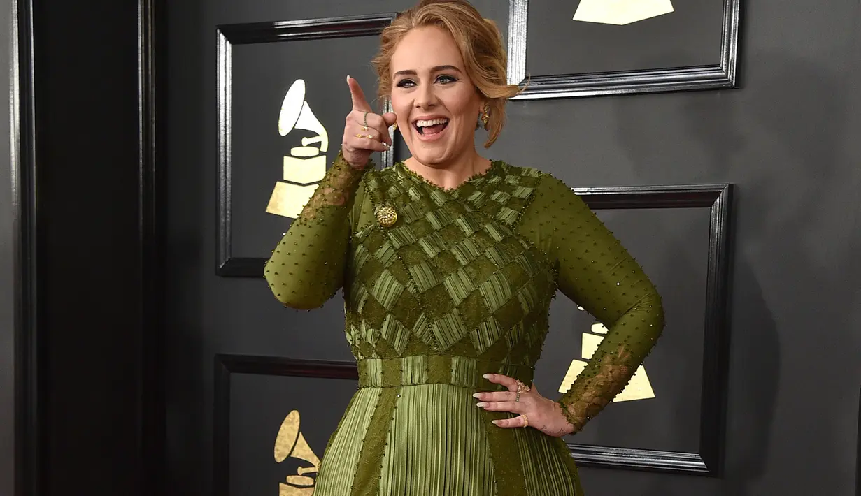 Penyanyi asal Inggris, Adele bereaksi saat berpose di karpet merah ajang bergengsi Grammy Awards 2017, di Staples Center, Los Angeles, Minggu (12/2). Pelantun "Hello" itu tampil dengan gaya busananya yang khas. (Photo by Jordan Strauss/Invision/AP)