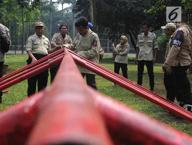 Anggota Taruna Siaga Bencana (Tagana) Kota Tangerang Selatan menyusun kerangka besi di Situ Gintung, Ciputat, Kamis (12/7). Kegiatan tersebut merupakan latihan membuat Shelter (pengungsian). (Merdeka.com/Arie Basuki)