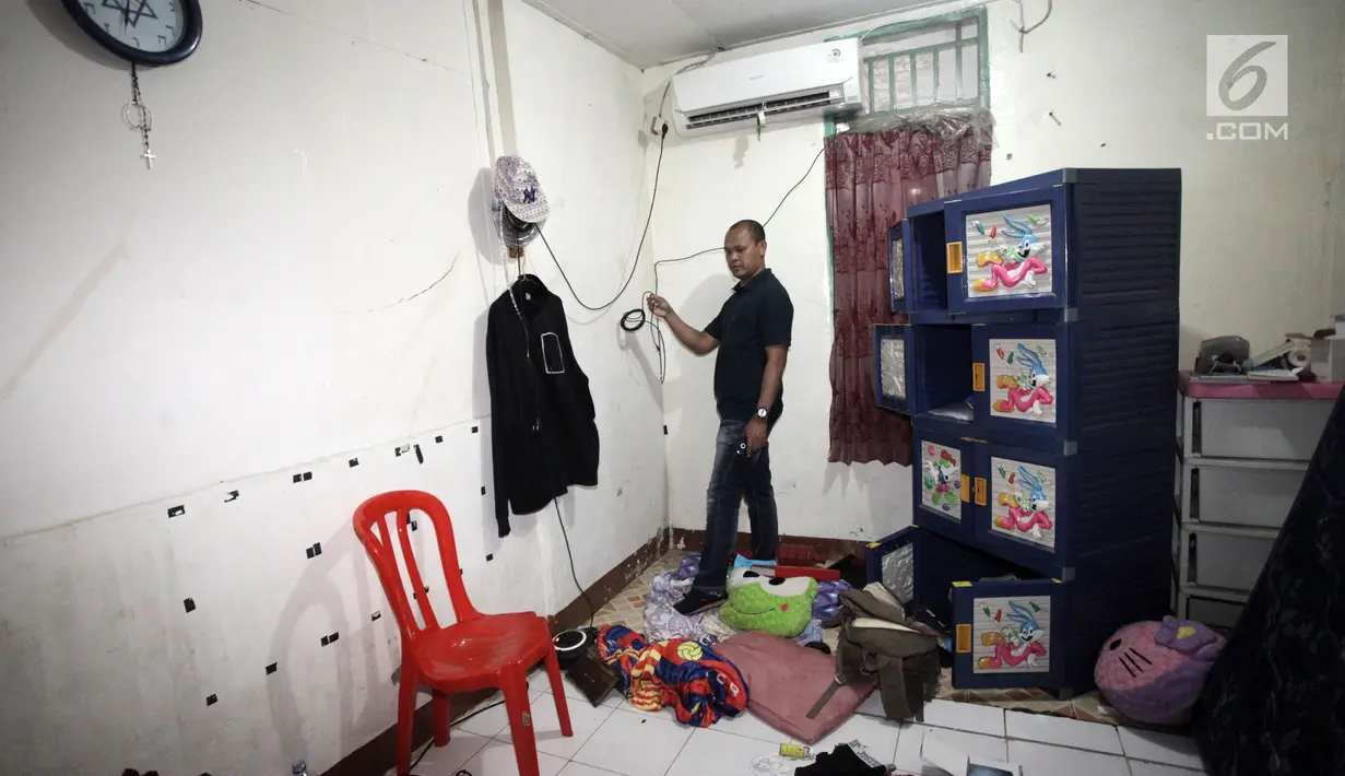 Petugas berada di sebuah rumah kawasan Kampung Ambon, Jakarta, seusai penggerebekan, Rabu (24/1). Saat digerebek para pelaku tengah melakukan transaksi dan beberapa orang tengah mengkonsumsi barang haram tersebut. (Liputan6.com/Arya Manggala)