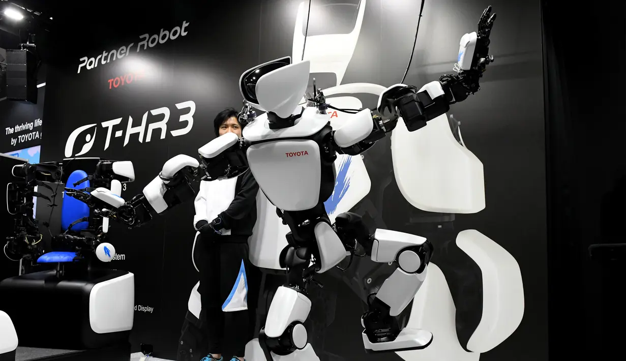 Robot humanoid generasi ketiga T-HR3 berusaha menjaga keseimbangannya saat berdiri dengan satu kaki selama Pameran Robot Internasional 2017 di Tokyo (29/11). Robot T-HR3 adalah hasil eksplorasi Toyota secara global. (AFP/Toru Yamanaka)
