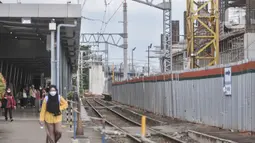 Calon penumpang kereta listrik Commuterline (KRL) saat melintas di dekat proyek pembangunan Stasiun Manggarai, Jakarta, Rabu (22/2/2023). Stasiun Manggarai nantinya akan menjadi stasiun antarmoda yang terintegrasi dengan LRT, Transjakarta dan transportasi umum lainnya serta melayani KA Bandara dan nantinya Kereta Jarak Jauh. (merdeka.com/Iqbal S Nugroho)