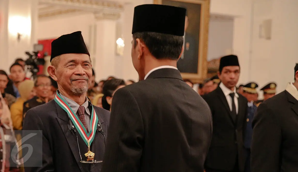 Presiden Jokowi (kanan) memberikan tanda kehormatan Bintang Budaya Paramadharma kepada sastrawan dan budayawan, Goenawan Mohamad di Istana Negara, Jakarta, Kamis (13/8).  (Liputan6.com/Faizal Fanani)