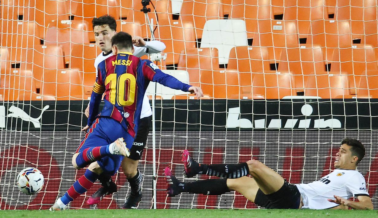 Striker Barcelona, Lionel Messi, mencetak gol ke gawang Valencia pada laga Liga Spanyol di Stadion Mestalla, Minggu (2/5/2021). Barcelona menang dengan skor 2-3. (AFP/Jose Jordan)
