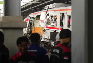 Para pekerja memeriksa kondisi lokomotif Kereta Api Jarak Jauh (KAJJ) Argo Bromo Anggrek dan salah satu gerbong Kereta Rel Listrik (KRL) Commuter Line yang mengalami kecelakaan di Stasiun Bekasi Timur, Bekasi, Jawa Barat, Selasa 28 April 2026. (AP Photo/Tatan Syuflana)