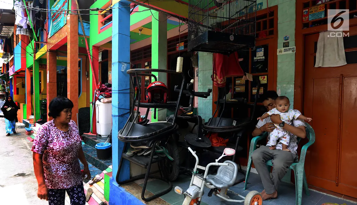 Warga beraktivitas dengan suasana dinding warna-warni di Kampung Penas Tanggul, Cipinang Besar Selatan, Jakarta, Kamis (2/11). Kampung warna-warni tanpa rokok tersebut dibuat warga guna melindungi perempuan dan anak. (Liputan6.com/Johan Tallo)