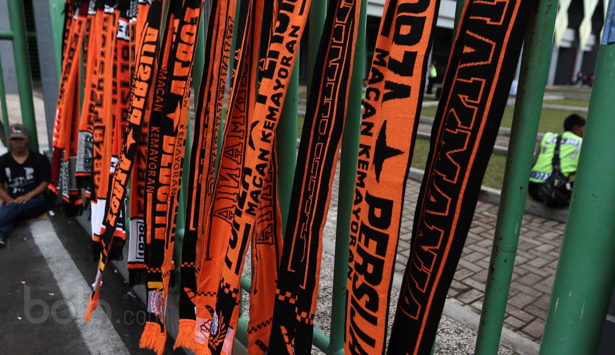 Pedagang atribut Persija menunggu pembeli di Stadion Patriot, Bekasi, Kamis (4/5/2017). Persija Jakarta akan menjamu Madura United pada lanjutan Liga 1 2017. (Bola.com/Nicklas Hanoatubun)