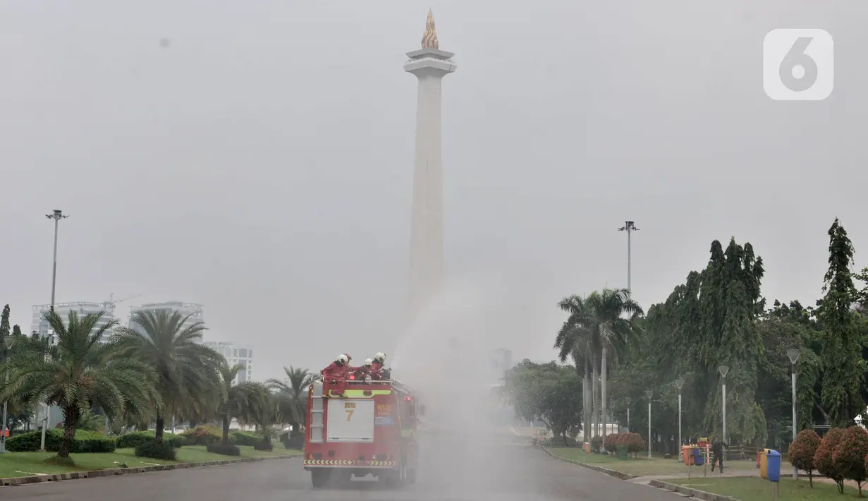 Petugas pemadam kebarakan menyemprotkan cairan disinfektan di kompleks Monumen Nasional (Monas), Jakarta, Senin (30/3/2020). Penyemprotan disinfektan ini dilakukan guna memutus rantai penyebaran virus Corona atau Covid-19 di pusat kota. (merdeka.com/Iqbal S. Nugroho)