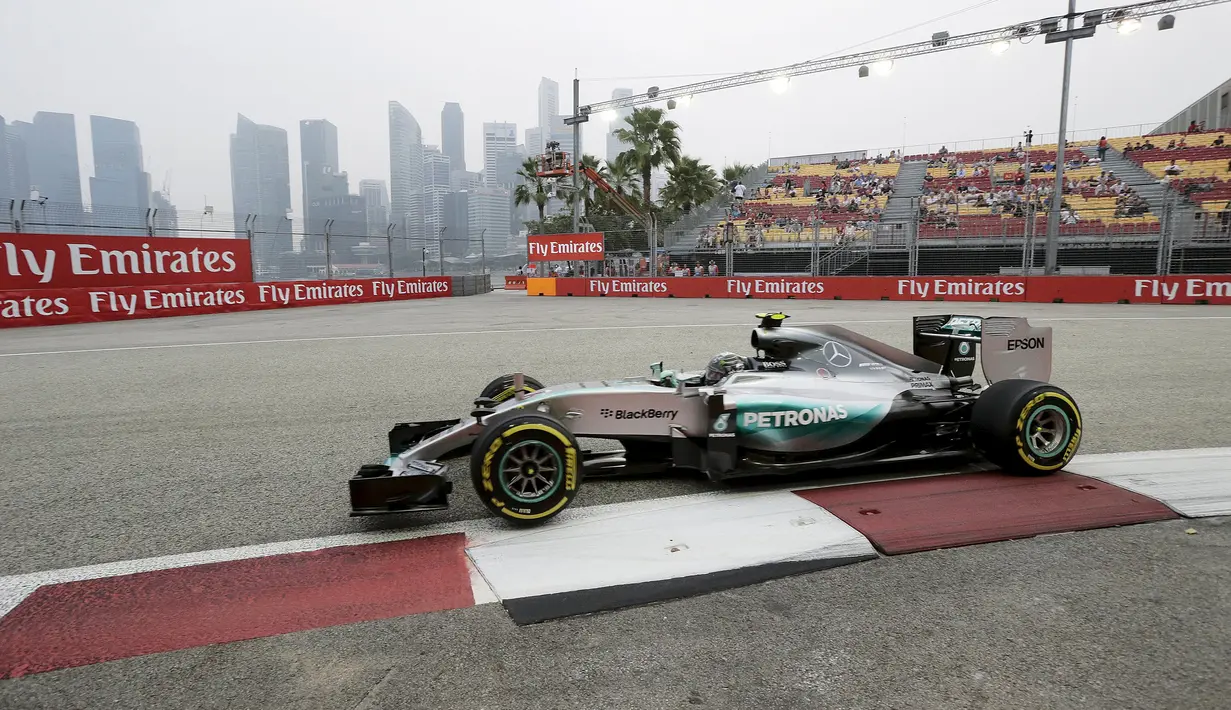 Pembalap Mercendez Formula 1, Nico Rosberg melakukan sesi latihan jelang Grand Prix Singapura F1 di Sirkuit Marina Bay (18/9/2015). Kabut asap yang menyelimuti sirkuit tak menyurutkan pembalap untuk tetap melakukan pemanasan. (REUTERS/Tim Chong)