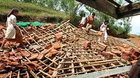 Sejumlah warga dan anak-anak membersihkan puing rumah mereka yang ambruk akibat diterjang angin puting beliung, di Desa Palenga'an Daya, Pamekasan, Madura.(Antara)