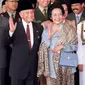 Presiden BJ Habibie didampingi istrinya Ainun Habibie melambaikan tangan kepada wartawan saat tiba di Gedung Parlemen, Jakarta, 21 Sptember 1999. Habibie bakal dikebumikan di Taman Makan Pahlawan Kalibata Jakarta Selatan pada Kamis, 12 September 2019. (AFP Photo/Oka Budhi)