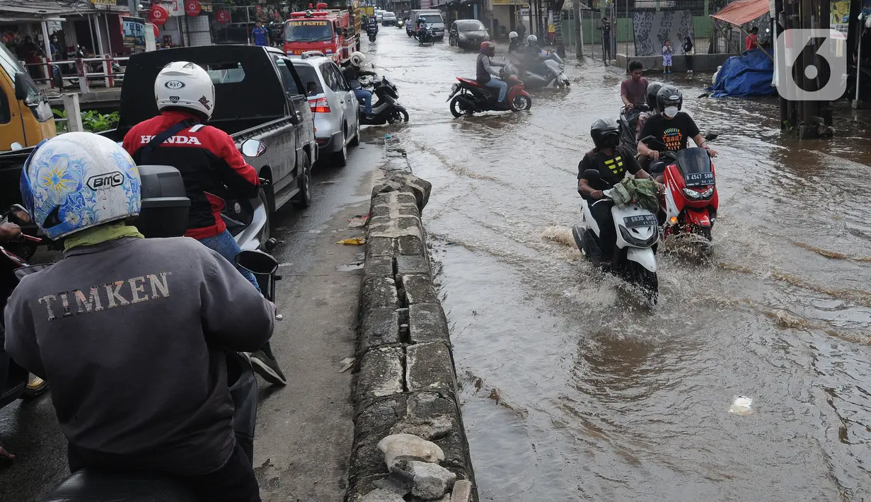 Pengendara melewati banjir yang menggenangi kawasan perempatan Mampang, Depok, Jawa Barat, Rabu (18/05/20222). Banjir tersebut disebabkan meluapnya Kali Mampang. Menurut pejabat setempat, banjir terjadi akibat adanya batang pohon yang tersangkut di kolong jembatan Mampang. (merdeka.com/Arie Basuki)