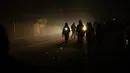 Warga Palestina yang mengungsi akibat pemboman Israel di Jalur Gaza berjalan dalam kegelapan dengan senter di kamp tenda darurat di daerah Muwasi, Minggu (31/12/2023). Israel telah mendorong warga Palestina untuk pindah ke Muwasi, dengan mengatakan bahwa mereka akan aman dari serangan pengeboman Israel. (AP Photo/Fatima Shbair)