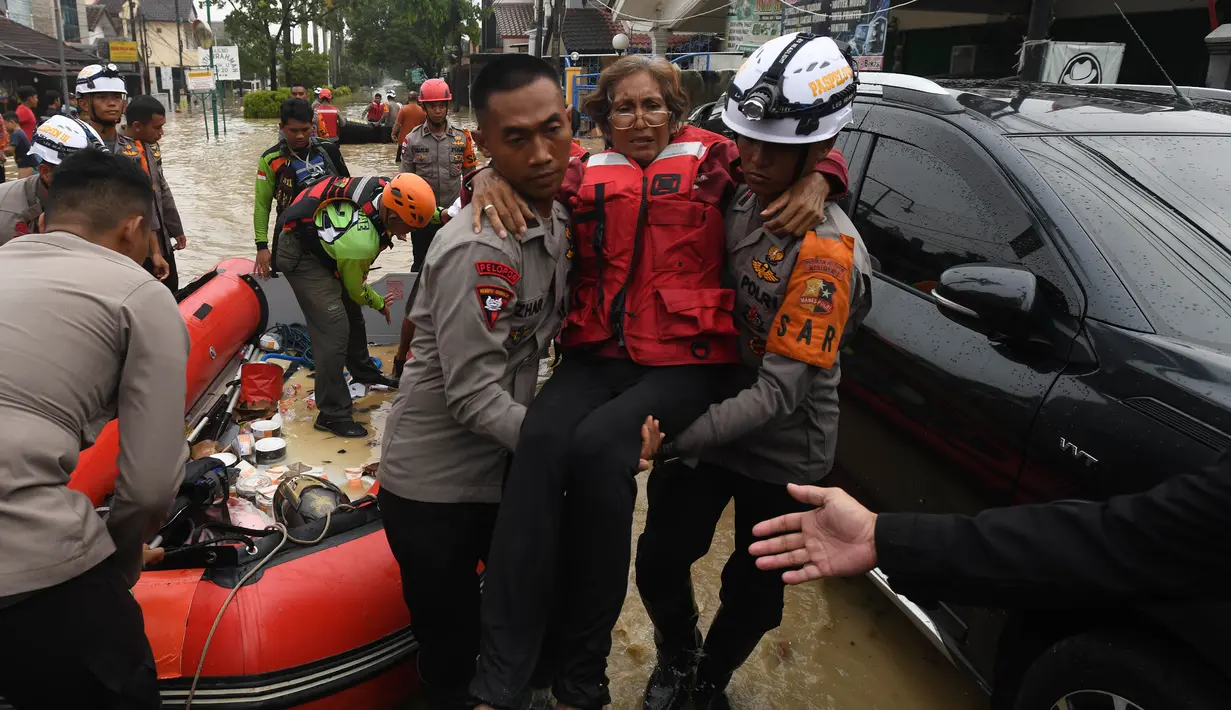 Personel Brimob Mabes Polri mengevakuasi korban banjir di Perumahan Vila Nusa Indah 3, Kabupaten Bogor, Jawa Barat, Selasa (4/3/2025). (merdeka.com/Arie Basuki)