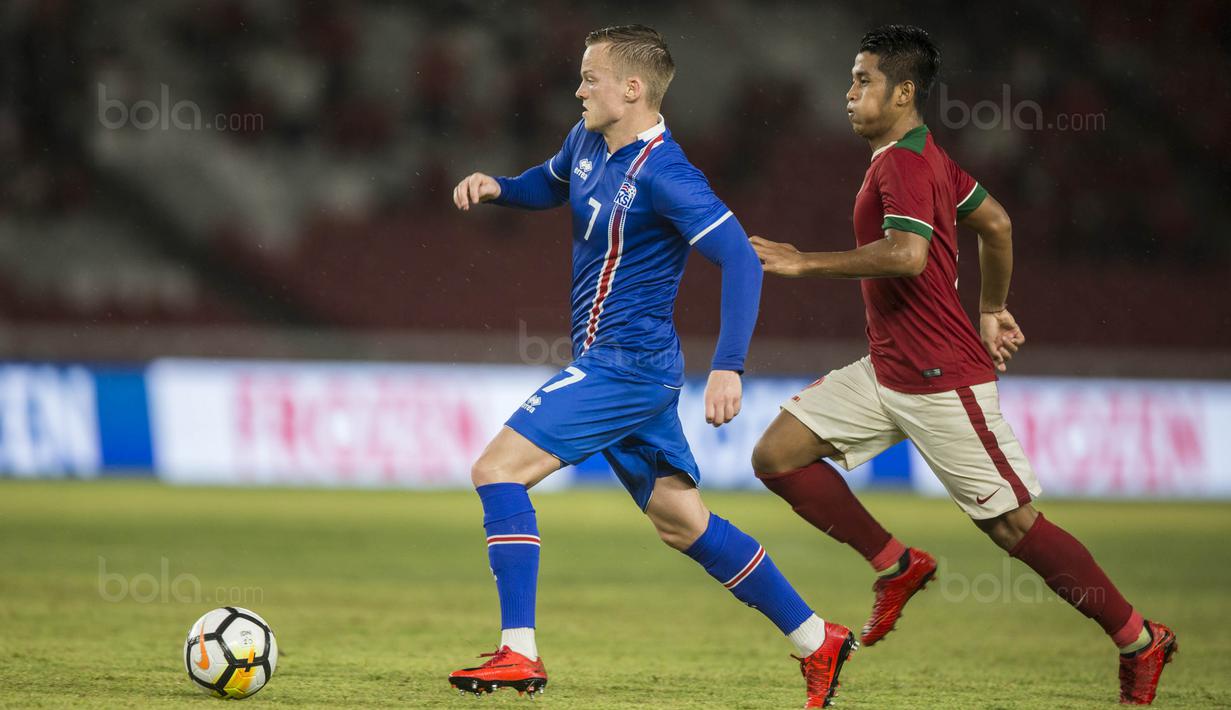 Striker Islandia, Aron Sigurdarson, menghindari kejaran dari bek Timnas Indonesia, Putu Gede, pada laga persahabatan di SUGBK, Jakarta, Minggu (14/1/2018). Indonesia kalah 1-4 dari Islandia. (Bola.com/Vitalis Yogi Trisna)