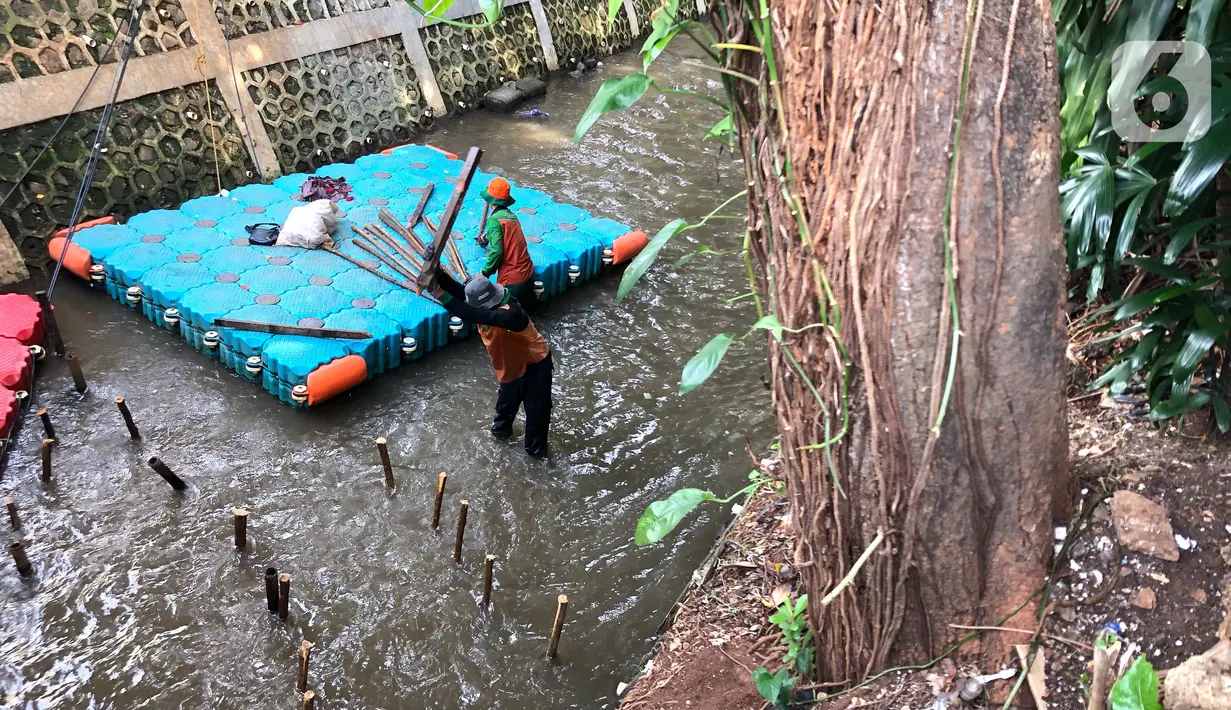 Petugas membuat jebakan sampah di Kali Pancoran, Jakarta, Kamis (12/11/2020). Jebakan sampah tersebut dibuat guna memermudah petugas saat membersihkan kali, terutama saat musim hujan. (Liputan6.com/Immanuel Antonius)