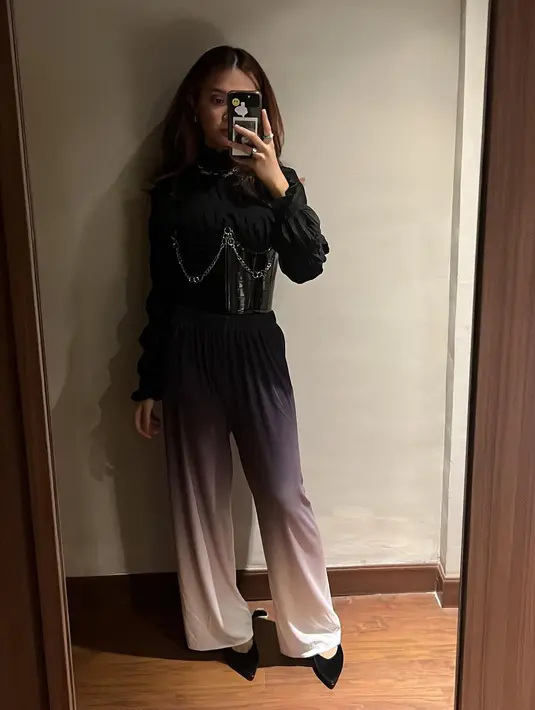 Blus hitam kian menarik dipadukan bustier beraksen chain dan ombre culotte pants.  [Foto: IG/rahmaniaastrini].