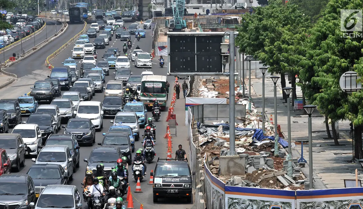 Kepadatan arus kendaraan saat melintas di depan proyek penataan ulang trotoar Jalan Jenderal Sudirman, Jakarta, Kamis (25/10). Proyek tersebut mempersempit jalur pejalan kaki dan menyebabkan kemacetan kendaraan. (Merdeka.com/Iqbal Nugroho)