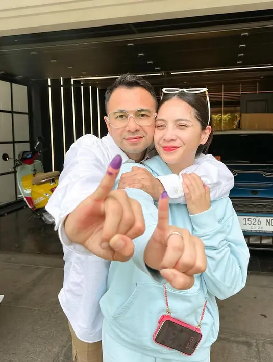 Pasangan artis Raffi Ahmad dan Nagita Slavina pun telah memberikan hak suaranya dengan memamerkan jari bertinta ungu. Nagita memilih mengenakan sweater hoodie warna baby blue dipadukan case phone strap warna pink. [@raffinagita1717]