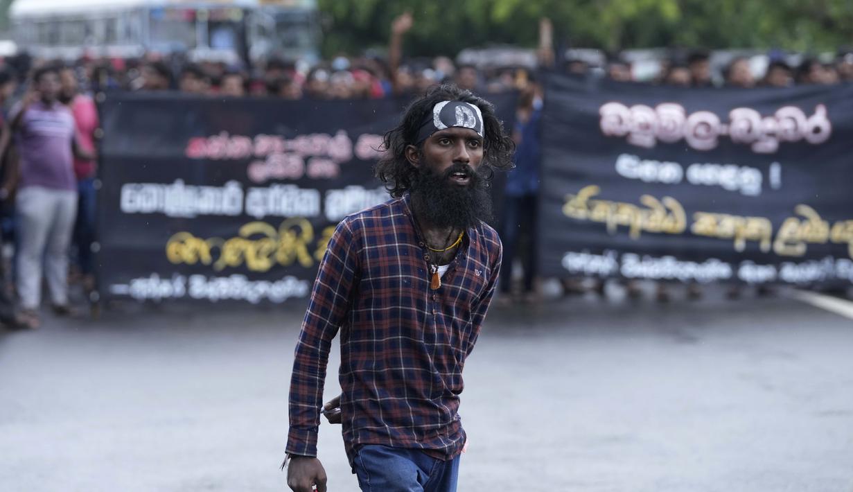 Seorang pria memimpin protes anti-pemerintah oleh mahasiswa Sri Lanka menuntut pengunduran diri presiden Gotabaya Rajapaksa di dekat parlemen di Kolombo, Sri Lanka (8/4/2022). (AP Photo/Eranga Jayawardena)