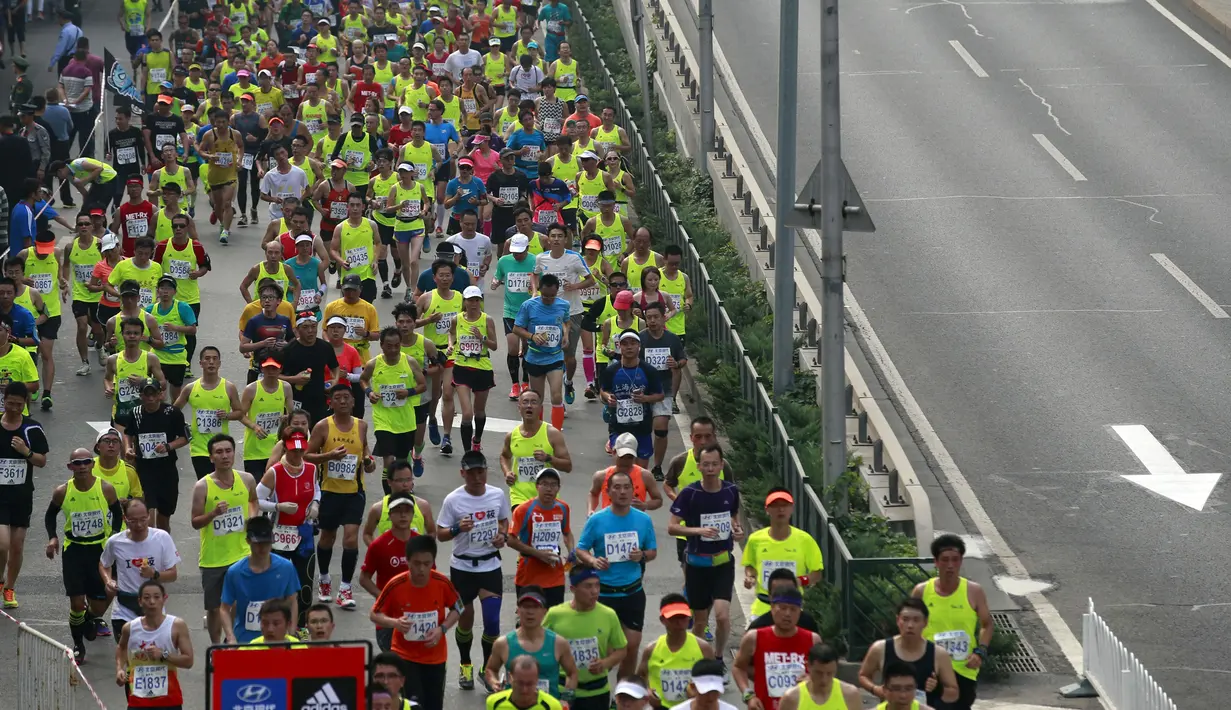 Ribuan pelari memenuhi ruas jalan saat Beijing International Marathon di Beijing, China, Minggu (20/9/2015). Sekitar 30.000 pelari ikut ambil bagian dalam acara yang berlangsung tiap tahun. (REUTERS/Kim Kyung-Hoon)