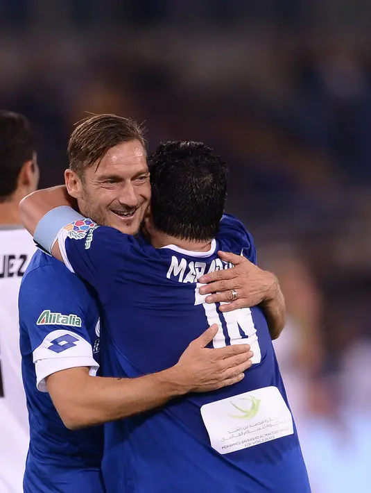 Marodana memeluk penyerang AS Roma, Francesco Totti usai pertandingan amal 'United for Peace' di stadion Olimpyco, Roma, Italia (12/10). Maradona bermain selama 90 menit dalam pertandingan amal ini. (AFP Photo/Filippo Monteforte)