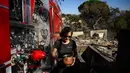 Kobaran api juga mengancam lebih kurang 3.500 bangunan di permukiman, peternakan dan area pertanian di pinggiran kota di sekitar Camarillo, Ventura, California. Tampak dalam foto, Robin Wallace usai membersihkan dan mengganti air untuk ikan peliharaannya di rumah keluarganya di West Highland Drive yang hancur akibat kebakaran hutan dan gunung pada 8 November 2024 di Camarillo, California. (Patrick T. Fallon/AFP)