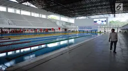 Pewarta melintas di sisi kolam renang di Stadion Aquatik Gelora Bung Karno pasca dilakukan renovasi, Jakarta, Jumat (10/11). Renovasi fisik Stadion Aquatik Gelora Bung Karno dinyatakan selesai dan siap digunakan. (Liputan6.com/Helmi Fithriansyah)