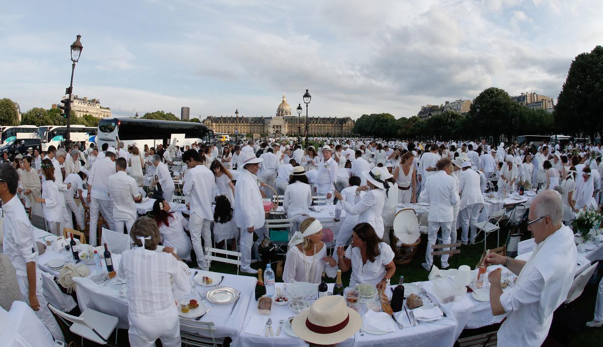Orang-orang berpakaian putih berkumpul bersiap untuk makan malam bersama atau "Diner en Blanc" yang ke-30 di Paris, Prancis (3/6). Tempat dilaksanakannya acara ini akan dirahasiakan oleh penyelenggara hingga 2-1 jam sebelum dimulai. (AFP/Francois Guillot)