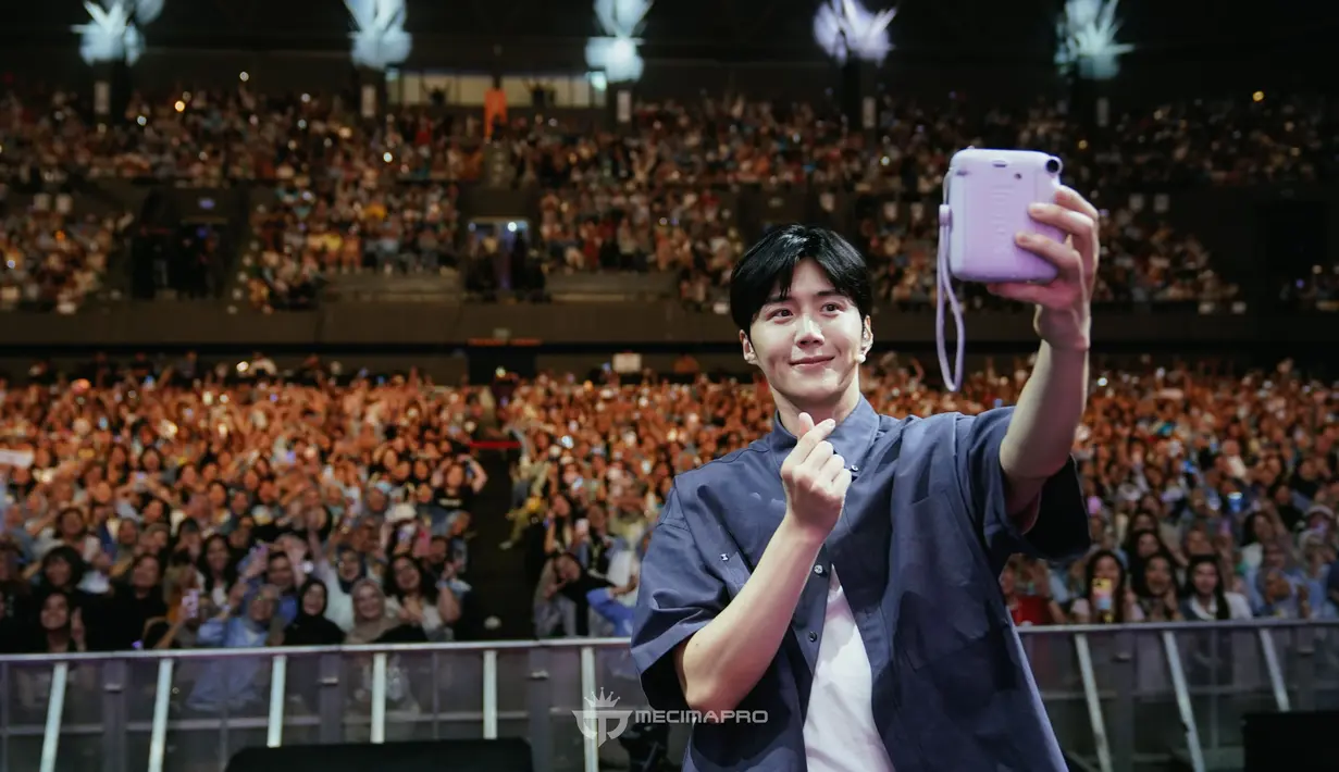<p>Kim Seon Ho melakukan selfie bersama ribuan penggemar di Tennis Indoor Senayan. Dia berpose dengan finger heart.(Foto: Mecimapro)</p>