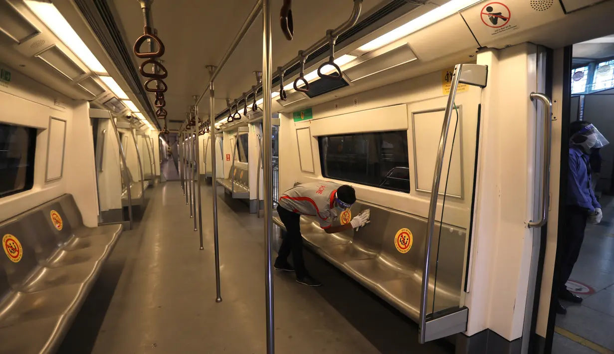 Seorang pekerja membersihkan interior gerbong metro di New Delhi, Kamis (3/9/2020). Jaringan Delhi Metro bersiap untuk melanjutkan layanan secara bertahap mulai 7 September setelah lebih dari 5 bulan ditutup karena pandemi virus corona Covid-19. (AP Photo/Manish Swarup)