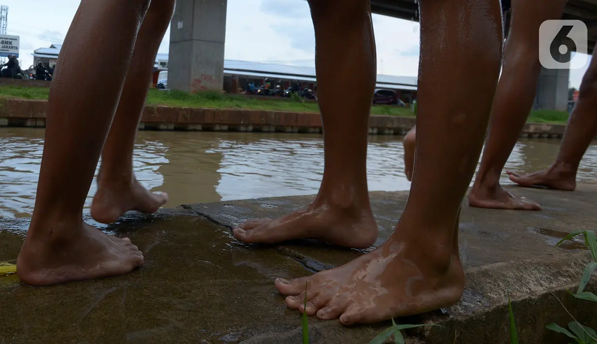 Sejumlah anak bermain dan berenang di aliran Kalimalang, Jakarta, Sabtu (15/2/2020). Cuaca yang tidak menentu membuat aliran air terkadang menjadi deras sehingga akan membahayakan keselamatan anak-anak saat bermain dan berenang. (merdeka.com/Imam Buhori)