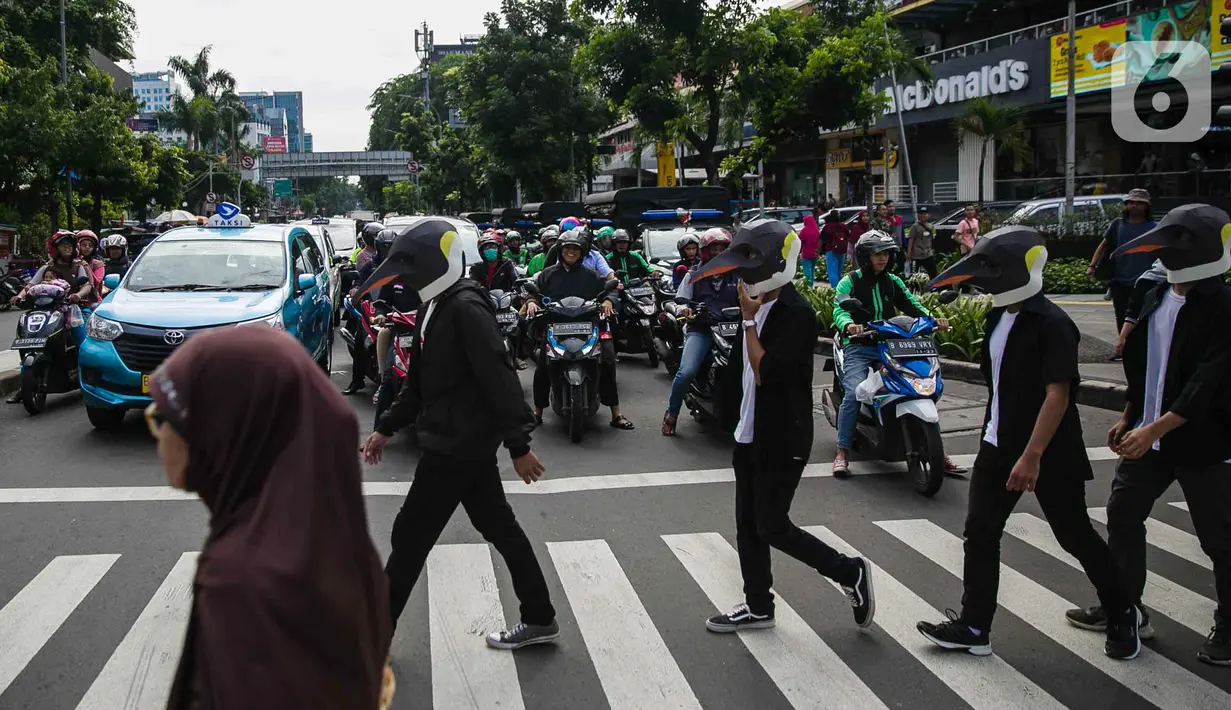 Sejumlah aktivis Greenpeace mengenakan topeng penguin saat menggelar aksi dalam car free day di kawasan Thamrin, Jakarta, Minggu (9/2/2020). Mereka mengajak pemerintah untuk berpartisipasi dalam mewujudkan Perjanjian Laut Internasional (Global Ocean Treaty). (Liputan6.com/Faizal Fanani)