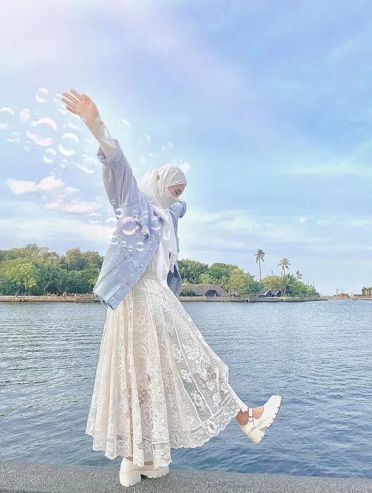 Seperti potret ini, Inara memadukan lace dress dan hijab putih dengan jaket jeans. [Foto: IG/mommy_starla].
