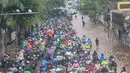 Pemerintah Provinsi DKI Jakarta berupaya menanggulangi situasi ini dengan melakukan operasi modifikasi cuaca untuk mengurangi intensitas hujan. Tampak dalam foto, antrean pengendara motor yang mencoba menerobos banjir di Jalan Daan Mogot, Jakarta, Jumat (23/1/02026). (merdeka.com/ Arie Basuki)