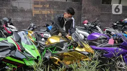 Polisi memberi label pada motor gede milik tersangka Quotex, Doni Salmanan di halaman Bareskrim Polri, Jakarta, Senin (14/3/2022). Selain sejumlah mobil mewah dan motor gede (moge), polisi juga menyita ponsel hingga akun YouTube Doni Salmanan. (Liputan6.com/Faizal Fanani)