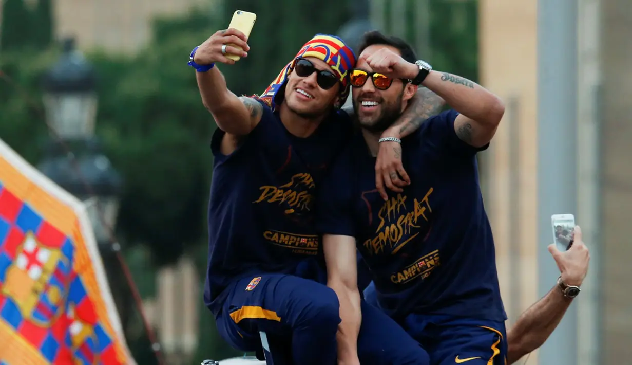 Neymar dan Claudio Bravo ber-selfie ria di atas bus saat pawai tim Barcelona untuk merayakan gelar La Liga ke-24, Minggu (15/5/2016). (AFP/Pau Barrena)