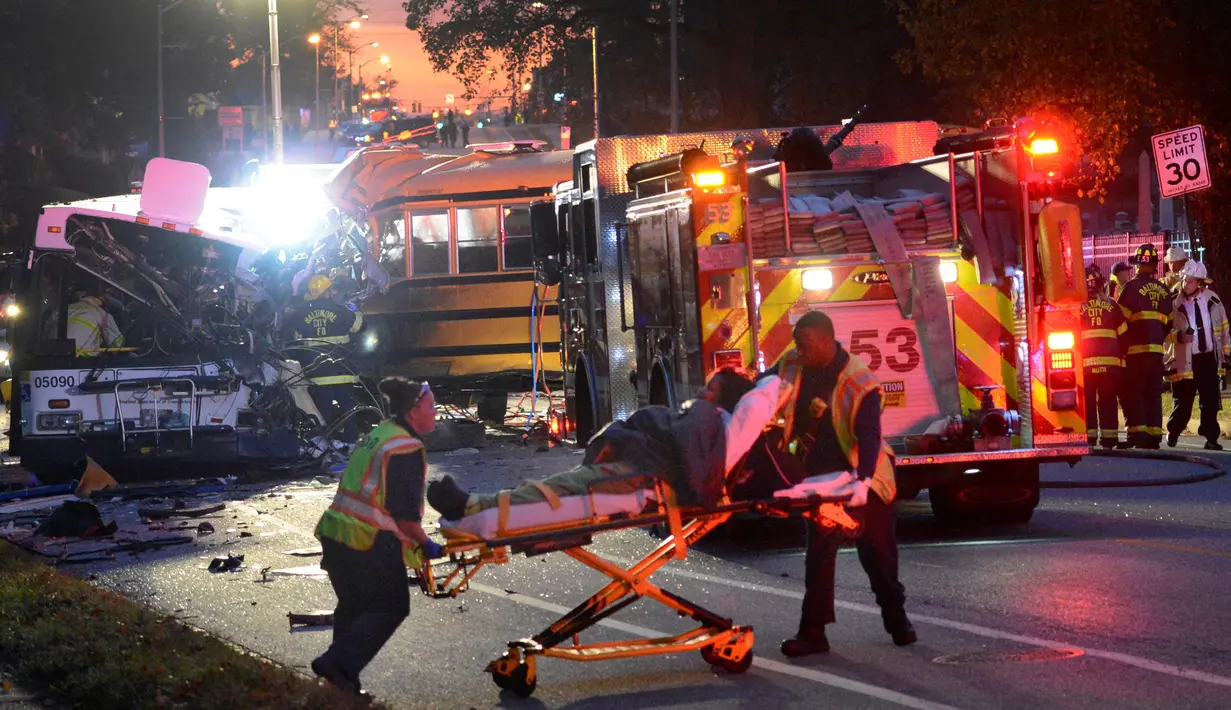 Petugas medis mengevakuasi korban tabrakan antara bus komuter dengan bus sekolah di Baltimore, Maryland, Selasa (1/11). Bus sekolah tanpa penumpang itu menabrak bagian depan bus komuter. (Courtesy Jeffrey F. Bill/Baltimore Sun via REUTERS)