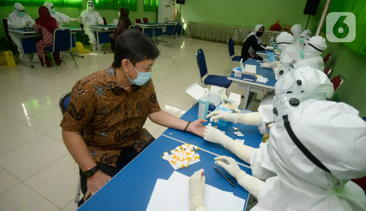 Tenaga pendidik SMP mengikuti tes pemeriksaan cepat COVID-19 (Rapid Test) di SMPN 3 Ciputat, Tangerang Selatan, Kamis (27/08/2020). Rapid tes yang diikuti 400 guru mencakupi wilayah Ciputat dan Ciputat Timur itu untuk mencegah penyebaran Covid-19 di lingkungan pendidikan. (merdeka.com/Dwi Narwoko)