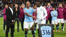 Kapten Manchester City, Vincent Kompany, mendampingi Yaya Toure saat perpisahan di Stadion Etihad, Rabu (9/5/2018). Laga tersebut menjadi ajang perpisahan sang pemain bersama The Citizens. (AFP/Oli Scarff)