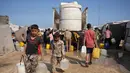 Para pengungsi Palestina berkumpul untuk mengambil air dari sebuah truk di kamp tenda darurat, Khan Younis, Jalur Gaza Selatan, Kamis 30 April 2026. Pengungsi Palestina di kamp-kamp pengungsian darurat di Khan Younis, Jalur Gaza Selatan masih menghadapi krisis air bersih yang parah. (AP Photo/Abdel Kareem Hana)