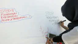 Salah satu warga membubuhkan pesan dalam Aksi Damai 5.000 Tandatangan Suarakan Hak-hak Sipil dan Anak-Perempuan' di Jakarta, (24/8/2014). (Liputan6.com/Herman Zakharia)