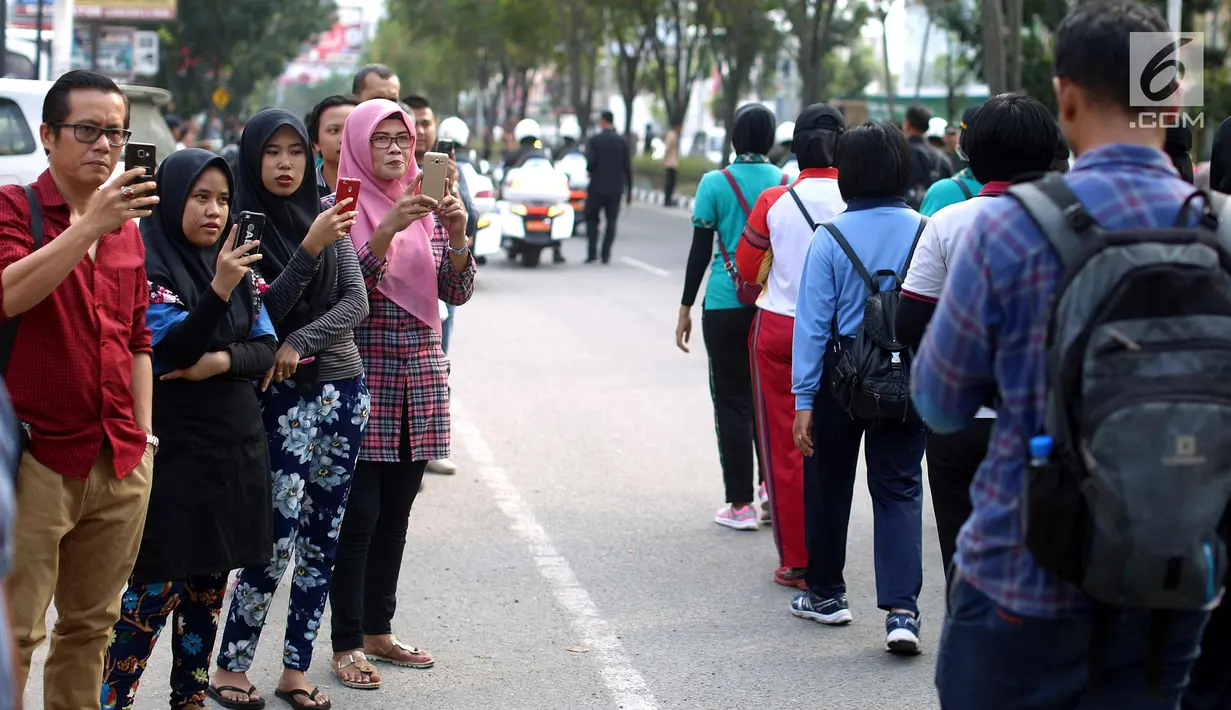 Warga mengabadikan momen simulasi kirab pernikahan Kahiyang Ayu dan Bobby Nasution, Medan, Rabu (22/11). Simulasi kirab ngunduh mantu Jokowi menjadi pusat perhatian warga sekitar. (Liputan6.com/Johan Tallo)