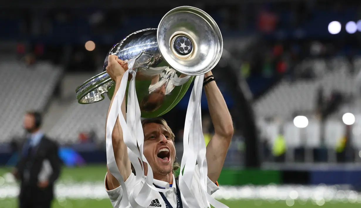 Selebrasi gelandang Real Madrid, Luka Modric dengan mengangkat trofi juara Liga Champions 2021/2022 setelah mengalahkan Liverpool pada laga final di Stade de France, Saint-Denis, Paris (28/5/2022). Pada musim 2021/2022 Real Madrid yang masih diperkuat seorang pemain Kroasia, yaitu Luka Modric berhasil menjuarai Liga Champions dengan mengalahkan Liverpool 1-0 di partai final. (AFP/Franck Fife)