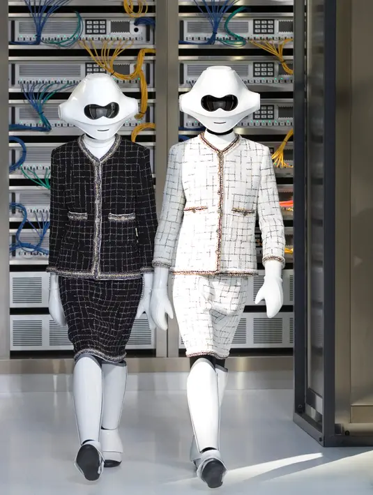 Aksi robot super fashionable yang mengenakan rancangan desainer Karl Lagerfeld untuk koleksi musim semi 2017 di Paris Fashion Week, Prancis, Selasa (4/10). Keduanya memakai setelan klasik Chanel dengan warna hitam dan putih. (REUTERS/Charles Platiau)