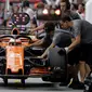 Kesibukan tim mekanik McLaren saat melihat kondisi mobil pebalap Stoffel Vandoorne di pit lane pada sesi latihan bebas F1 GP Singapura, Marina Bay City Circuit, (15/9/2017). (AP/Wong Maye-E)