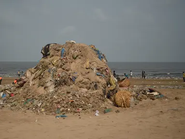 Petugas kebersihan berada di samping tumpukan sampah plastik terlihat di pantai Juhu di Mumbai, India (2/6). (AFP PHoto/Punit Paranjpe)